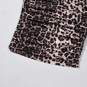 Detail of leopard print dress hem with elegant ruched fabric and high-quality stitching
