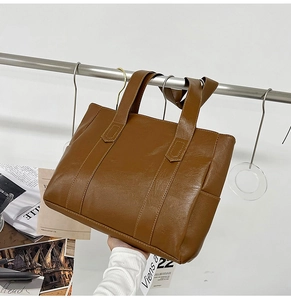 Detailed view of brown PU leather tote bag showing spacious interior and sturdy handles