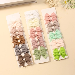 Multicolor bow hair clips for babies and girls presented in a stylish three-row set display