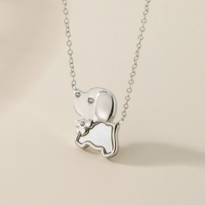 Close-up of a silver puppy pendant featuring white shell inlay and sparkling diamonds