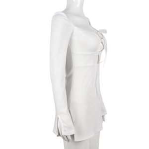 Detail of white waffle knit dress featuring lace-up cutout and split sleeve cuffs