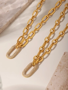 Macro shot of gold-plated thick chain necklace with oval micro-pave zirconia clasp