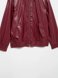 Detail of burgundy woven faux leather jacket showing zipper and pocket texture