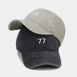 Détail de la broderie numéro 77 sur des casquettes en coton au style vintage délavé