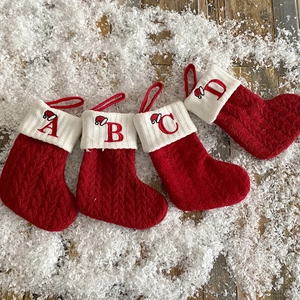 Set of four red and white knitted Christmas stockings with alphabet letters A B C D
