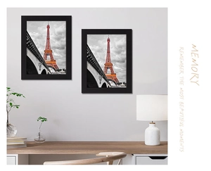 Detail of minimalist black picture frames featuring Eiffel Tower art on a grey wall