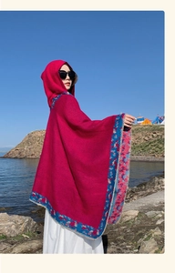 Ethnic hooded poncho in deep rose red featuring blue floral border by a scenic lake