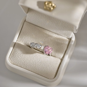 Detailed macro view of S925 silver ring featuring pink heart zircon stones in a white box