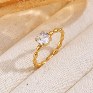 Macro shot of gold Mobius ring with sparkling zircon stone on beaded band detail