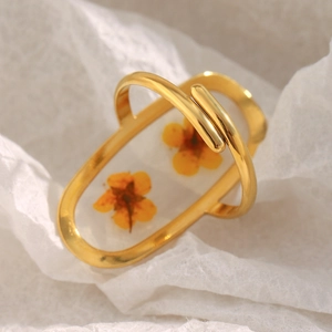 Detail of 18K gold plated ring featuring preserved yellow dried flowers in acrylic resin