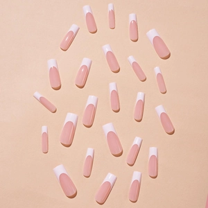 Long square French press-on nails with nude base and white tips on a matching pink background