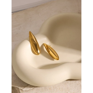 Polished 18K gold stainless steel teardrop earrings on a ceramic display tray