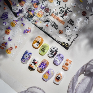 Gros plan de stickers à ongles Halloween avec motifs de citrouilles, fantômes et chats