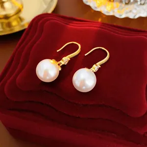 14K gold plated pearl drop earrings with zircon accents on a red velvet jewelry box