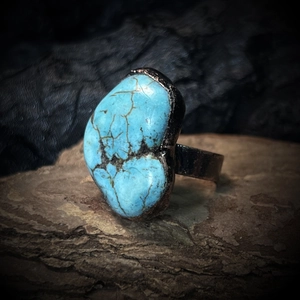 Macro shot of heart-shaped turquoise stone set in a vintage adjustable metal ring