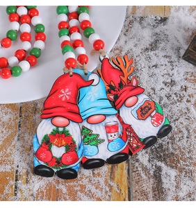 Detail of wooden Christmas gnome ornaments with red white green beads on wood table