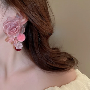 Detailed view of large pink mesh flower earrings with plush pompom and resin beads