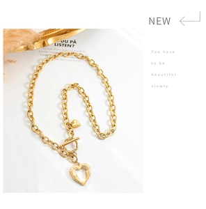 Macro view of gold toggle clasp chain with heart and winged heart pendants