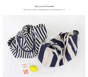 Close-up of navy blue and cream striped canvas tote bags with fresh lemon accents