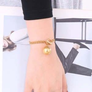 Details des goldenen Doppelketten-Armbands mit Hohlkugel-Anhänger und Knebelverschluss