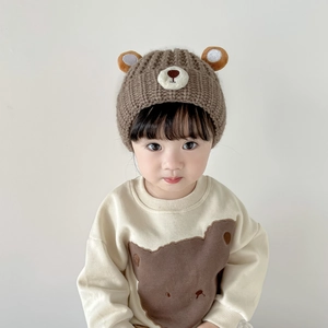 Close-up of baby knit bear hat and matching bear print sweatshirt on toddler model