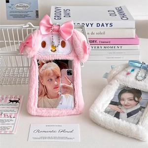 Detail view of plush bunny and puppy photo card holders with silk bows and metal chains