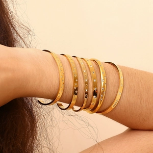 Elegant gold titanium steel bangles with starburst patterns and cubic zirconia for women