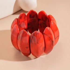 Detailed macro shot of a thick red acrylic bracelet with black marble marble smoke pattern