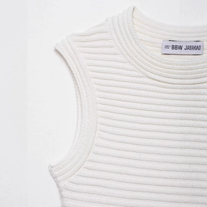 White sleeveless knit top with round neck and horizontal rib texture detail