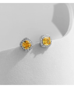 Macro view of luxury S925 silver stud earrings with yellow square cushion-cut diamonds