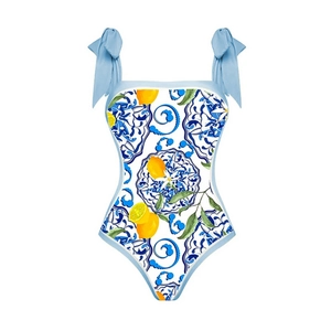 Detail of one-piece swimsuit with blue tile and lemon prints and shoulder tie bows