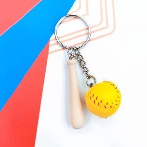 Detailed view of mini wooden baseball bat keychain with yellow ball and red stitching