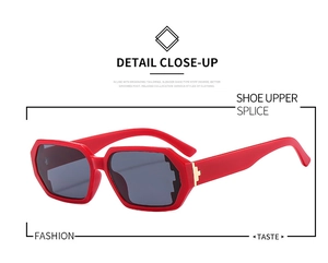 Detail view of red geometric sunglasses with dark grey lenses and gold metal hinges