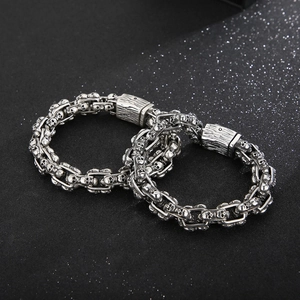 Macro shot of punk style steel skull bracelet links on a black textured background