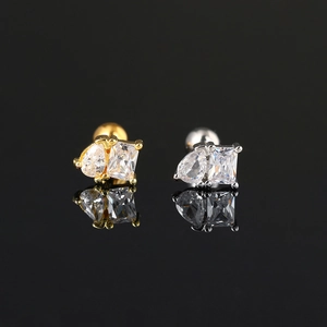 Detail view of gold and silver piercing studs with pear and emerald cut zircons