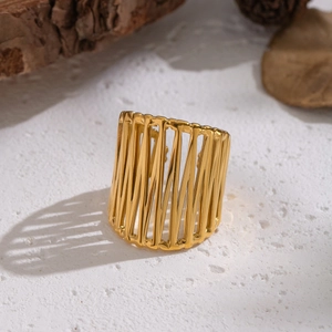 Golden hollow geometric wide band stainless steel ring on elegant natural background