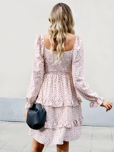 Detail of white floral dress featuring a smocked back design and ruffled layered hemline