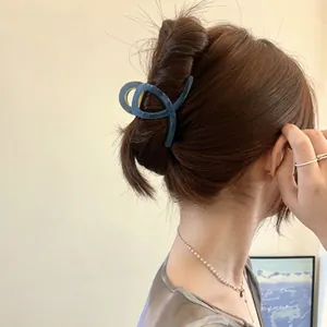 Pince à cheveux en acrylique bleu mat au design torsadé sur cheveux châtain foncé de dos