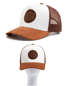 Detail of brown faux suede baseball cap showing mesh panels and round leather patch