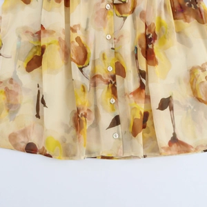 Detailansicht einer Chiffonbluse mit Blumenmuster und perlmuttfarbenen Knöpfen