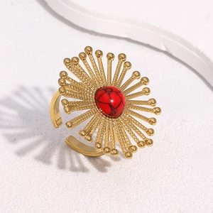 Macro view of dandelion-inspired gold stainless steel ring with a red stone center