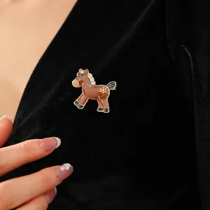 Pony shaped enamel brooch with snowflakes and rhinestones on black velvet fabric