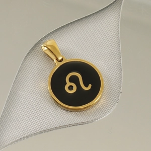 Macro shot of 18K gold plated constellation pendant with Leo symbol on black oil drop