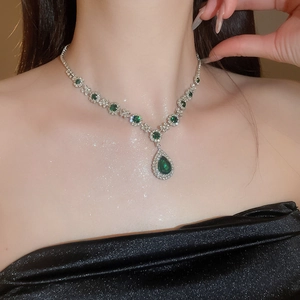 Detail of luxury teardrop green gemstone necklace set with sparkling silver accents