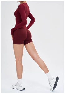 Détail d'un ensemble de sport sans couture rouge foncé avec haut court et short yoga