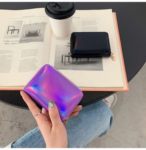 Close-up of holographic laser card holders with zip closures on a lifestyle background