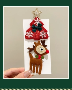 Detail of Christmas tree and reindeer hair clips on card with sequins and felt texture
