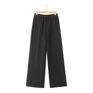 Detail of black wide-leg joggers featuring a drawstring elastic waist and central seam line