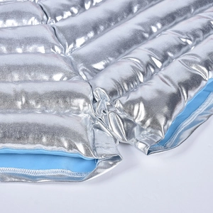 Close-up of quilted silver metallic fabric with blue lining and padded insulation