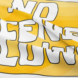 Close-up of bohemian yellow tapestry showing woven fabric texture and bold letter print